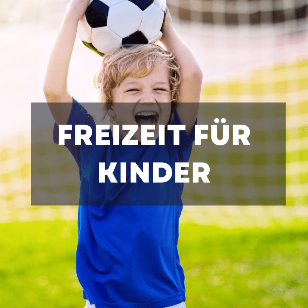 Ein Kind hält lachend einen Fußball über seinen Kopf und freut sich über seinen Freizeit-Spaß in Dänemark